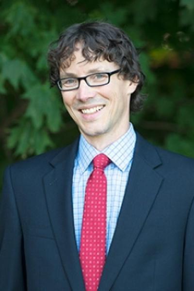 Headshot of male professor wearing glasses and a red tie